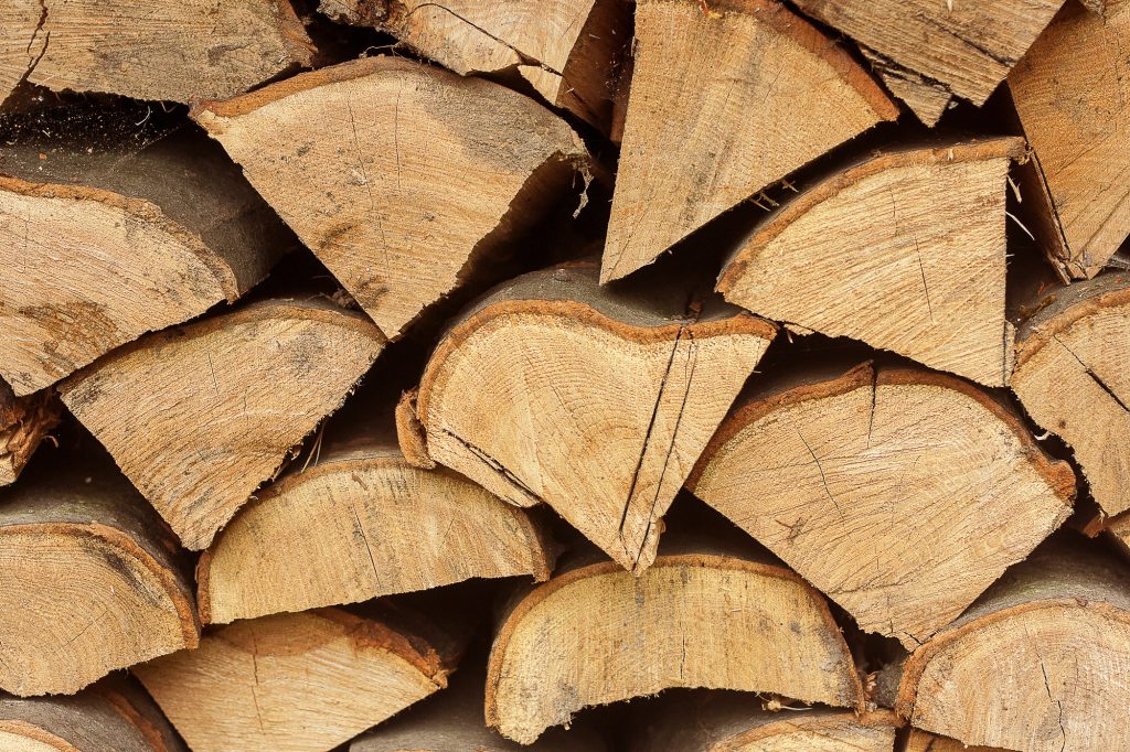 Firewood piles stacked together textured wooden background. Close up.